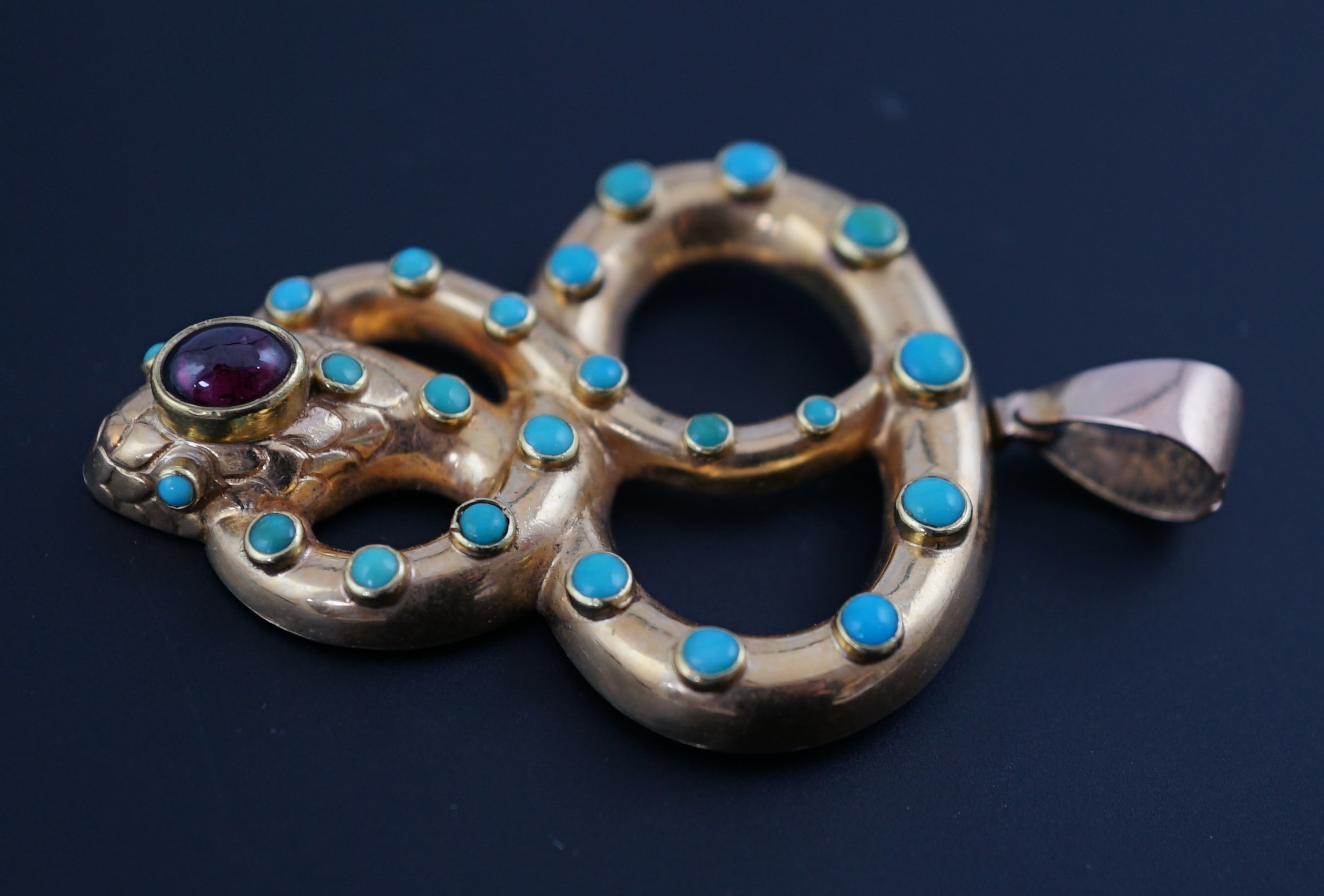 A Victorian gold, turquoise and cabochon garnet set entwined serpent pendant
